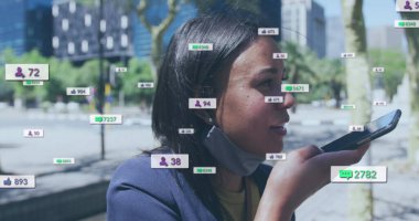 Sosyal medya simgeleri ve çift ırklı akıllı telefonlu yüz maskeli kadın üzerindeki numaralar. Küresel sosyal medya, iş dünyası, bulut hesaplama ve veri işleme kavramı dijital olarak oluşturuldu.