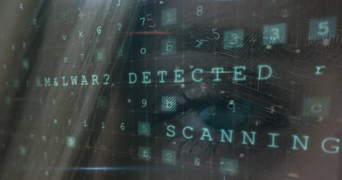 Beyaz bir kadın kötü amaçlı yazılım tespit mesajıyla bilgisayar ekranına bakıyor. Odaklanmış yüzünü loş bir odada gizleyen dijital kod ve tarama metni