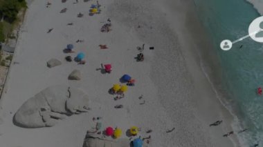 Şemsiyelerle plajda dinlenen insanların ağ bağlantıları. Teknoloji, bağlantı, rahatlama, boş zaman, tatil, ağ