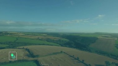 Yeşil enerji ve sürdürülebilirlik ikonları kırsal manzaranın havadan görünüşü üzerinde canlandırma yapar. Çevre dostu, yenilenebilir, güneş, rüzgar, çevre, koruma