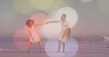 El ele tutuşup gülümseyen, sahilde ışık animasyonlu bir çift. Romantizm, mutluluk, ilişki, tatil, tatil, aşk