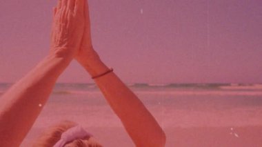 Sahilde yoga yapan, pembe animasyon üzerinde kollarını açan bir kadın. Farkındalık, sağlık, fitness, meditasyon, rahatlama, sağlıklı yaşam tarzı