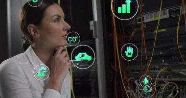 Beyaz iş kadınlarının bilgisayar sunucuları tarafından ekolojik simgelerin ve veri işlemlerinin animasyonu. Küresel çevre, bağlantılar, hesaplama ve veri işleme kavramı dijital olarak oluşturulmuş video.