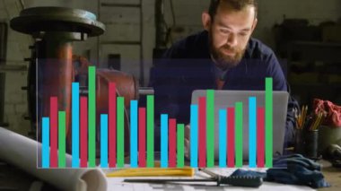 Atölyedeki dizüstü bilgisayar kullanılarak, Kafkas erkek mekaniği üzerinden finansal veri işleme animasyonu. İş, finans, bilgisayar, atölye ve dijital arayüz kavramı dijital olarak oluşturulmuş video.