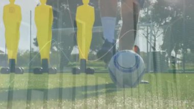Finansal veriler ve borsa animasyonları üzerinde sahada top oynayan bir futbolcu. İş, finans, yatırım, ekonomi, analiz, spor