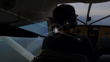 Kokpitte uçan ve ağ bağlantıları olan bir uçağın pilotu. Havacılık, teknoloji, ağ, dijital, iletişim, bağlantı