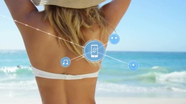 Kumsaldaki beyaz kadın üzerindeki cihaz simgeleriyle bağlantı ağlarının animasyonu. Genel tatil, bağlantılar, hesaplama ve veri işleme kavramı dijital olarak oluşturulmuş video.
