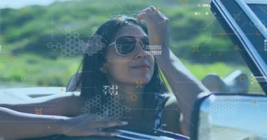 Arabaya yaslanmış, güneş gözlüklü, dijital ağlı ve veri işleme animasyonlu bir kadın. Teknoloji, bağlantı, modern, yenilik, moda, otomotiv