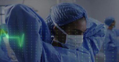 Koruyucu teçhizat ayarlanıyor, hastane geçmişinde kalp atışı animasyonu olan bir tıp uzmanı. Sağlık, doktor, kardiyoloji, güvenlik, ekipman, tıp