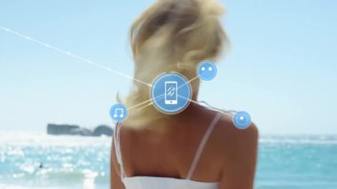 Kumsaldaki beyaz kadın üzerindeki cihaz simgeleriyle bağlantı ağlarının animasyonu. Genel tatil, bağlantılar, hesaplama ve veri işleme kavramı dijital olarak oluşturulmuş video.