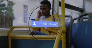 Otobüste akıllı telefon kullanan Afro-Amerikan kadının takipçilerinin sayısı artıyor. Küresel iletişim, sosyal medya, bağlantılar ve dijital arayüz konsepti dijital olarak oluşturulmuş video.