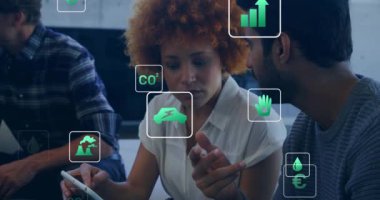 Ofisteki tablet kullanılarak farklı meslekdaşlar üzerinde ekoloji simgelerinin canlandırılması. İş, teknoloji ve dijital arayüz kavramı dijital olarak oluşturuldu.