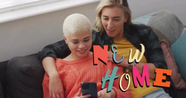 Evde akıllı telefon kullanan eşcinsel lezbiyen çiftin yeni ev mesajlarının animasyonu. Yeni ev, aşk, ilişki, mülk ve mutluluk konsepti dijital olarak oluşturulmuş video.