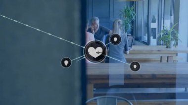 Ofisteki farklı iş adamlarının kalp ikonlarıyla olan bağlantılarının animasyonu. Küresel finans, iş, bağlantılar, hesaplama ve veri işleme kavramı dijital olarak oluşturulmuş video.