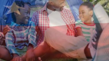 Afrika kökenli Amerikalı baba ve çocukların çadırda oturması üzerine Şili bayrağının animasyonu. Küresel yaşam tarzı, aile ve vatanseverlik kavramı dijital olarak oluşturulmuş video.