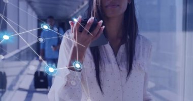 Havaalanında akıllı telefon kullanan çift ırklı iş kadınıyla olan bağlantıların animasyonu. Küresel finans, iş, bağlantılar, hesaplama ve veri işleme kavramı dijital olarak oluşturulmuş video.