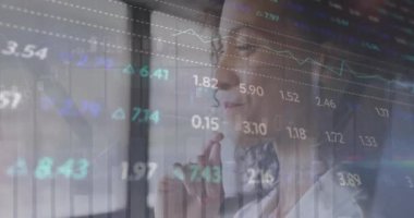 Ofisteki iki ırklı iş kadınıyla ilgili finansal veri işleme animasyonu. Küresel finans, iş, bağlantılar, hesaplama ve veri işleme kavramı dijital olarak oluşturulmuş video.