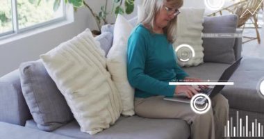 Dizüstü bilgisayar kullanan yaşlı beyaz bir kadının finansal veri işleme animasyonu. Dijital olarak oluşturulmuş küresel finansman, iletişim, bilgisayar ve dijital arayüz kavramı.