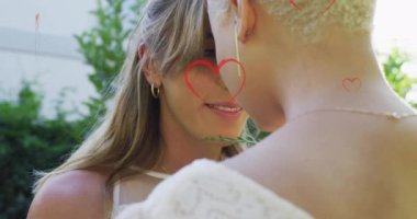 Birbirlerine sarılan farklı kadın evli çiftlerin üzerinde yüzen kalplerin canlandırması. Gurur, yaşam tarzı ve kutlama konsepti dijital olarak oluşturulmuş video.