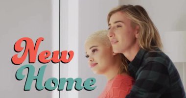 Evde eşcinsel lezbiyen çiftin pencerede kucaklaşması üzerine yeni ev mesajı animasyonu. Yeni ev, aşk, ilişki, mülk ve mutluluk konsepti dijital olarak oluşturulmuş video.