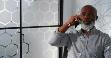 Akıllı telefon kullanarak Afro-Amerikan iş adamlarının üzerine ağ ve simgelerle dünyanın animasyonu. Küresel iş, bağlantılar, hesaplama ve veri işleme kavramı dijital olarak oluşturulmuş video.