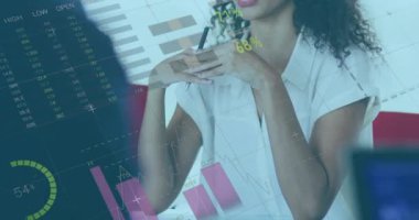 Ofisteki iki ırklı iş kadınıyla ilgili finansal veri işleme animasyonu. Küresel finans, iş, bağlantılar, hesaplama ve veri işleme kavramı dijital olarak oluşturulmuş video.