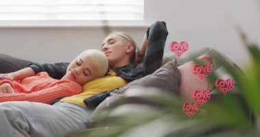 Kalplerin animasyonu. Mesajların evde uyuyan farklı kadın çiftten geliyor. Yaşam tarzı, aşk ve dijital arayüz konsepti dijital olarak oluşturulmuş video.