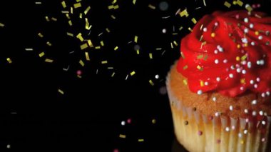 Düşen konfeti animasyonlarıyla çevrili kırmızı şekerli ve şekerli kek. Tatlı, kutlama, neşeli, tatlı, parti, renkli