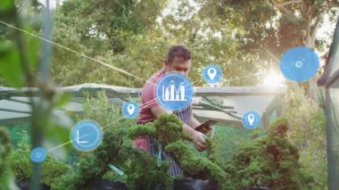 Bahçıvan, veri işleme tableti ve bahçe üzerinde konum ikonları canlandırması kullanıyor. Bahçıvanlık, teknoloji, tarım, yenilik, akıllı tarım, bahçıvanlık