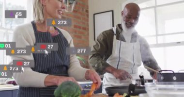 Mutfakta birlikte yemek pişirirken, çeşitli çiftler sosyal medya tebligatı alıyor. teknoloji, gelişigüzel, etkileşim