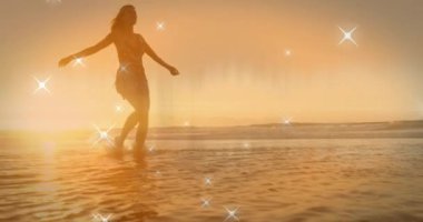 Beyaz kadın üzerinde yüzen yıldızların deniz kenarında yürümesi. Yaşam tarzı ve dijital arayüz kavramı, dijital olarak oluşturulmuş video.