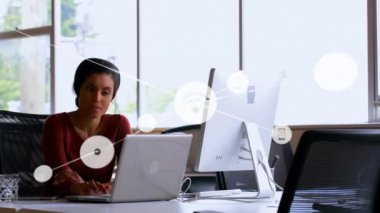 Ofisteki dizüstü bilgisayar kullanan iki ırklı iş kadınıyla olan bağlantıların animasyonu. İş, teknoloji ve dijital arayüz kavramı, dijital olarak oluşturulmuş video.