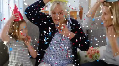 Kanepede doğum günü kutlaması, aile konfeti animasyonunun tadını çıkarıyor. Kutlama, mutluluk, doğum günü partisi, birliktelik, eğlence