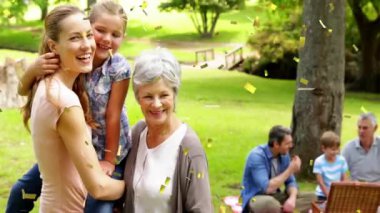 Park 'ta pikniğin tadını çıkarıyorum, arka planda konfeti animasyonu olan bir aile. Dışarıda, kutlama, eğlence, eğlence, kaynaşma, doğa