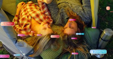 Çadırda uzanan çift, sorgu numaraları animasyonlarıyla çevrili. Teknoloji, kamp, dijital, veri, macera, açık hava