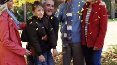 Mutlu bir ailenin sonbahar parkında eğlenmesi üzerine konfeti animasyonu. Kutlama, bağ, mutluluk, açık hava, doğa