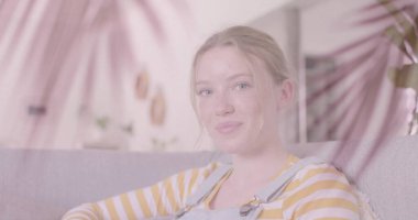 Evde dinlenen, gülümseyen beyaz bir genç kızın üzerindeki palmiye yaprakları. Gençlik, boş zaman, hafta sonu ve yaşam tarzı, dijital olarak oluşturulmuş görüntü.