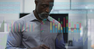 Gömlekli orta yaşlı Afro-Amerikan bir adamın resmi mali verileri inceliyor. Kısa gri saçları, odaklanmış gözleri var ve renkli grafikler gösteren dijital bir ekranın önünde duruyor.