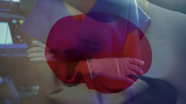 Japon bayrağının yüzü maskeli beyaz kadın cerrah üzerinde canlandırılması. Tıp, vatanseverlik ve dijital arayüz kavramı, dijital olarak üretilen video.