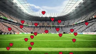 Yeşil sahası ve seyircisi olan futbol stadyumunun üzerinde Hearts animasyonu. Futbol, spor, aşk, tutku, kalabalık, kutlama