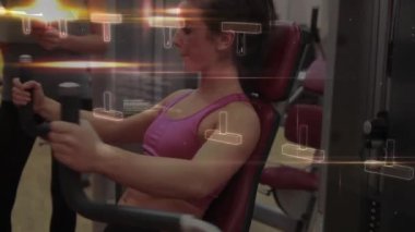 Spor salonunda egzersiz yapan beyaz bir çiftin DNA iplikçiklerinin ve veri işlemlerinin animasyonu. Teknoloji, spor ve dijital arayüz kavramı, dijital olarak üretilen video.