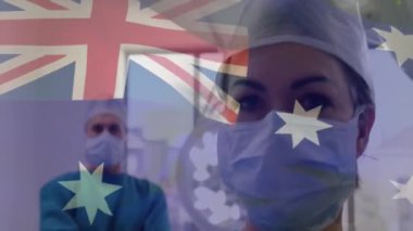 Avusturalya bayrağının yüzü maskeli beyaz cerrahlar üzerinde canlandırılması. Tıp, vatanseverlik ve dijital arayüz kavramı, dijital olarak üretilen video.