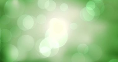 Yeşil Bokeh ışıkları bulanık arka planda hareket ediyor. Soyut, parlayan, çözülmüş, parıldayan, ışıldayan