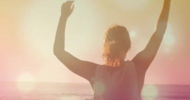 Sahilde yoga yapan melez bir kadının üzerindeki ışık lekelerinin canlandırılması. Spor, doğa ve dijital arayüz konsepti dijital olarak oluşturulmuş video.