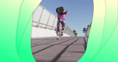 Köprüde koşan melez kadının üzerindeki yeşil şekillerin canlandırması. Spor, doğa ve dijital arayüz konsepti dijital olarak oluşturulmuş video.