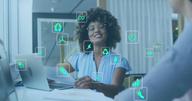 Dizüstü bilgisayar kullanan ve ofiste iş tartışan farklı meslektaşların ekoloji simgeleri. Küresel iş, ekoloji, finans ve dijital arayüz kavramı dijital olarak oluşturulmuş görüntü.