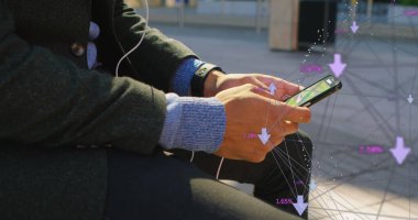 Çift ırklı genç profesyonel akıllı telefon tutuyor, dijital arayüzü gösteriyor. Koyu renk ceketli, gri kazaklı, ekrandaki renkli veri noktalarıyla etkileşim halinde.