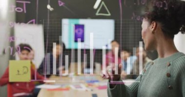 Sınıf arkaplanının üzerinde grafik animasyonu olan saydam panoda yazan bir kadın. İş, sunum, eğitim, strateji, veri, analitik kavram