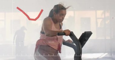 Durağan bisiklette egzersiz yapan, borsa grafik animasyonu yapan bir kadın. Fitness, egzersiz, bisiklet, teknoloji, yatırım, veri görselleştirme