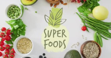 Süper yiyecekler, beyaz arka plandaki çeşitli sağlıklı malzemeler üzerine metin animasyonu. Beslenme, diyet, sağlık, temiz yeme, organik, antioksidan.